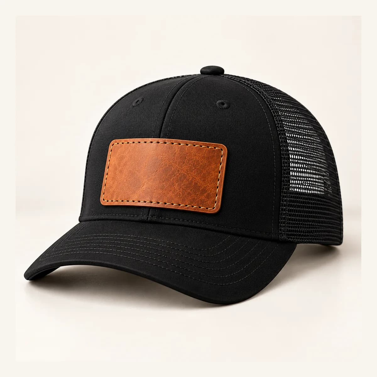 A black trucker cap with an engraved leather patch