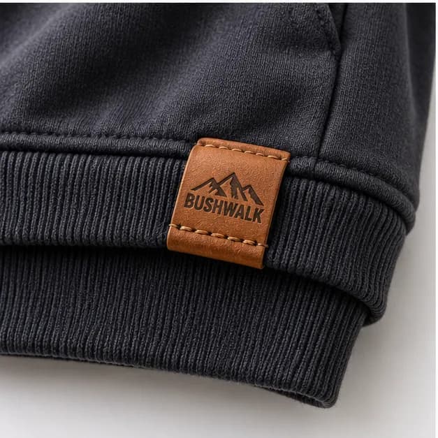 A Bushwalk leather label folded over a hoodie's ribbed hem