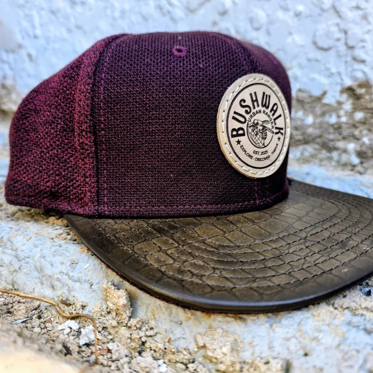 Bushwalk maroon snapback with a round leather patch